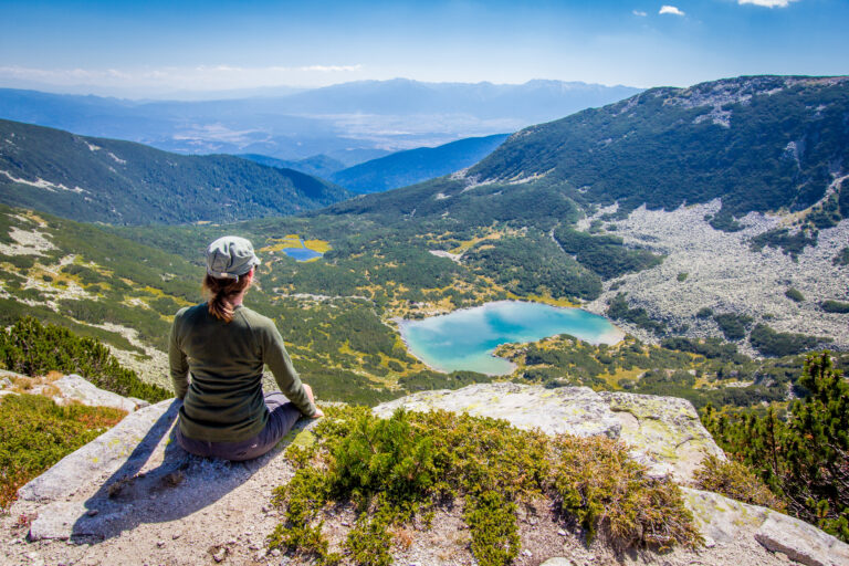 Traveler enjoying a scenic mountain view overlooking a lake and natural landscape